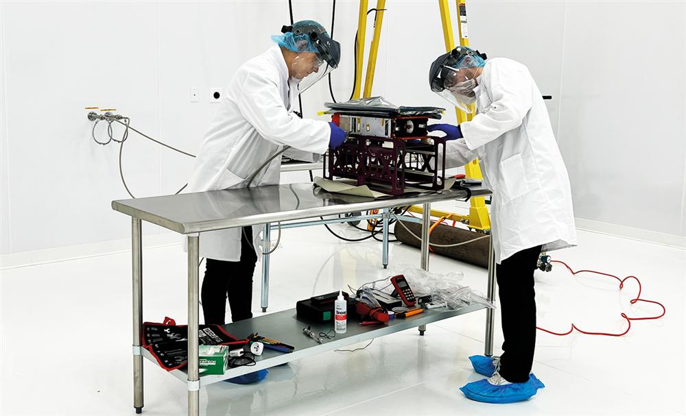 Impulso Space staff preparing a satellite payload in the Florida cleanroom